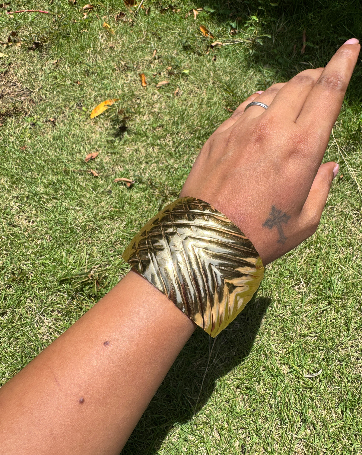Abstract arm cuff in brass with stripe embossing